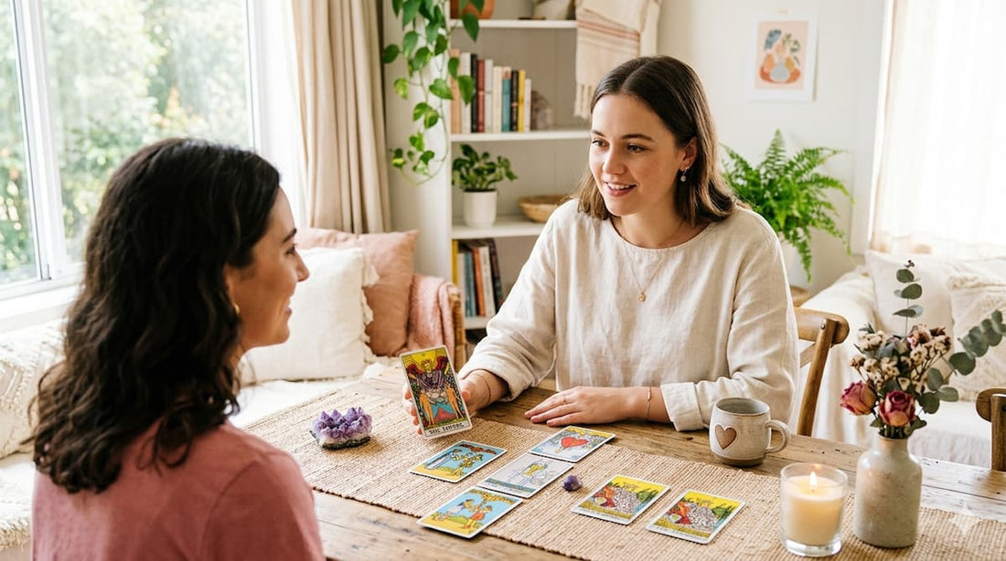 Leitura de tarot entre duas mulheres em ambiente acolhedor, com cartas abertas sobre a mesa, ilustrando como o tarot pode ajudar no amor e nas decisões afetivas.